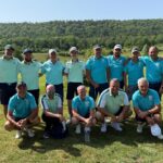 Équipe de golf posant sur un parcours verdoyant sous le soleil, vêtue de polos turquoise et blancs. Arrière-plan de collines boisées, ambiance décontractée et sportive, reflet de camaraderie et d’esprit d'équipe. Idéal pour illustrer des événements de golf, des compétitions amicales ou des activités de groupe en plein air.