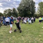 Groupe de golfeurs sur un parcours, rassemblés pour un briefing avant le départ. Plusieurs participants, hommes et femmes, sont équipés de sacs de golf sur des chariots. L'ambiance est conviviale et dynamique, avec des arbres en arrière-plan et un ciel nuageux. Cet événement met en avant la passion du golf et le partage entre amateurs du sport.