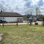 Activités en plein air dans un espace naturel, avec des adultes s'adonnant à la tonte de la pelouse et à d'autres tâches de jardinage. En arrière-plan, on peut voir des véhicules stationnés et un bâtiment avec une illustration de golfeur sur le mur. Le ciel est partiellement nuageux, créant une atmosphère propice aux loisirs en extérieur. Des équipements de jardinage sont visibles, soulignant l'engagement dans des activités de plein air.